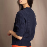 a woman wearing a cashmere aran sweater tee in navy blue