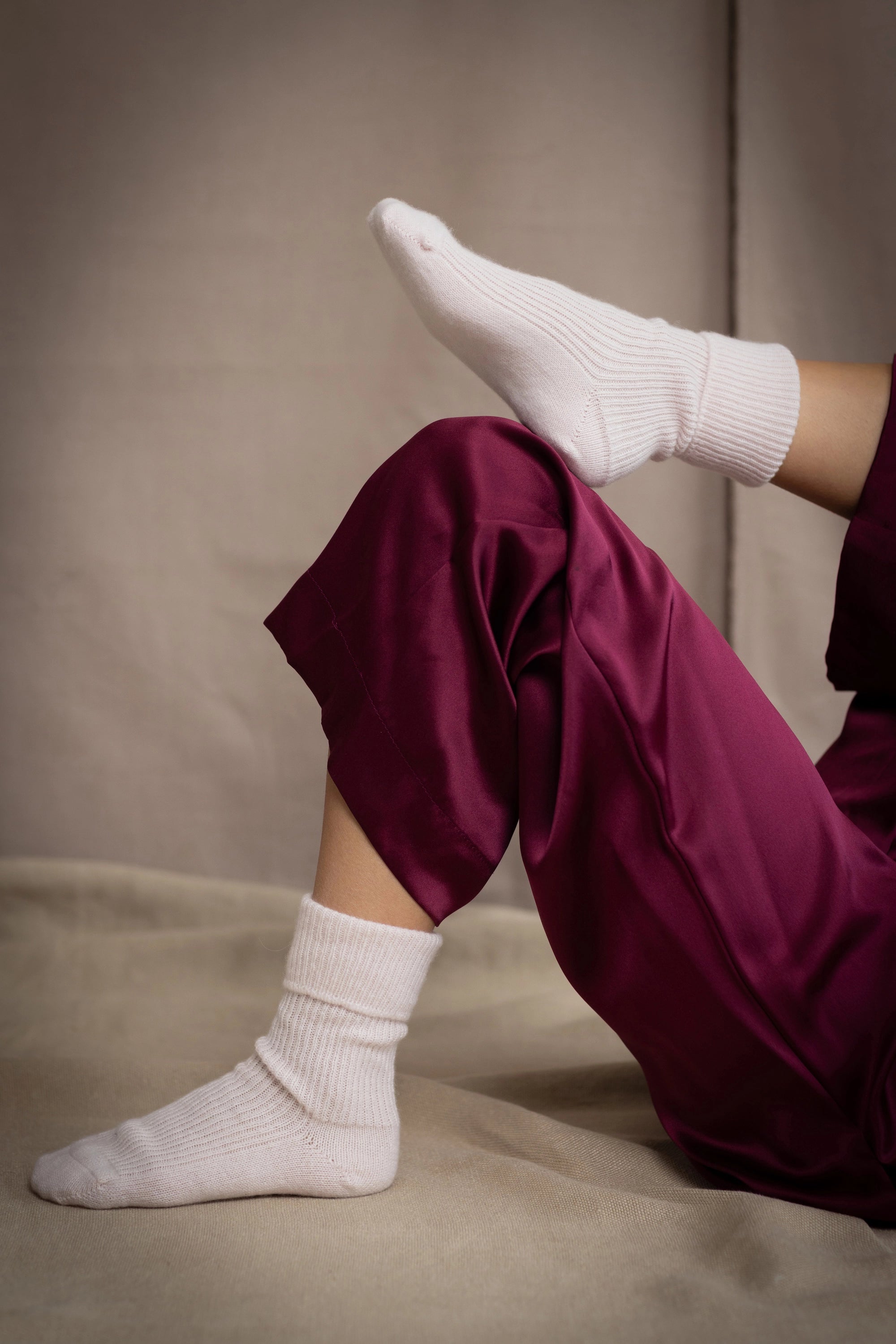 a woman wearing cashmere bed socks in pale pink