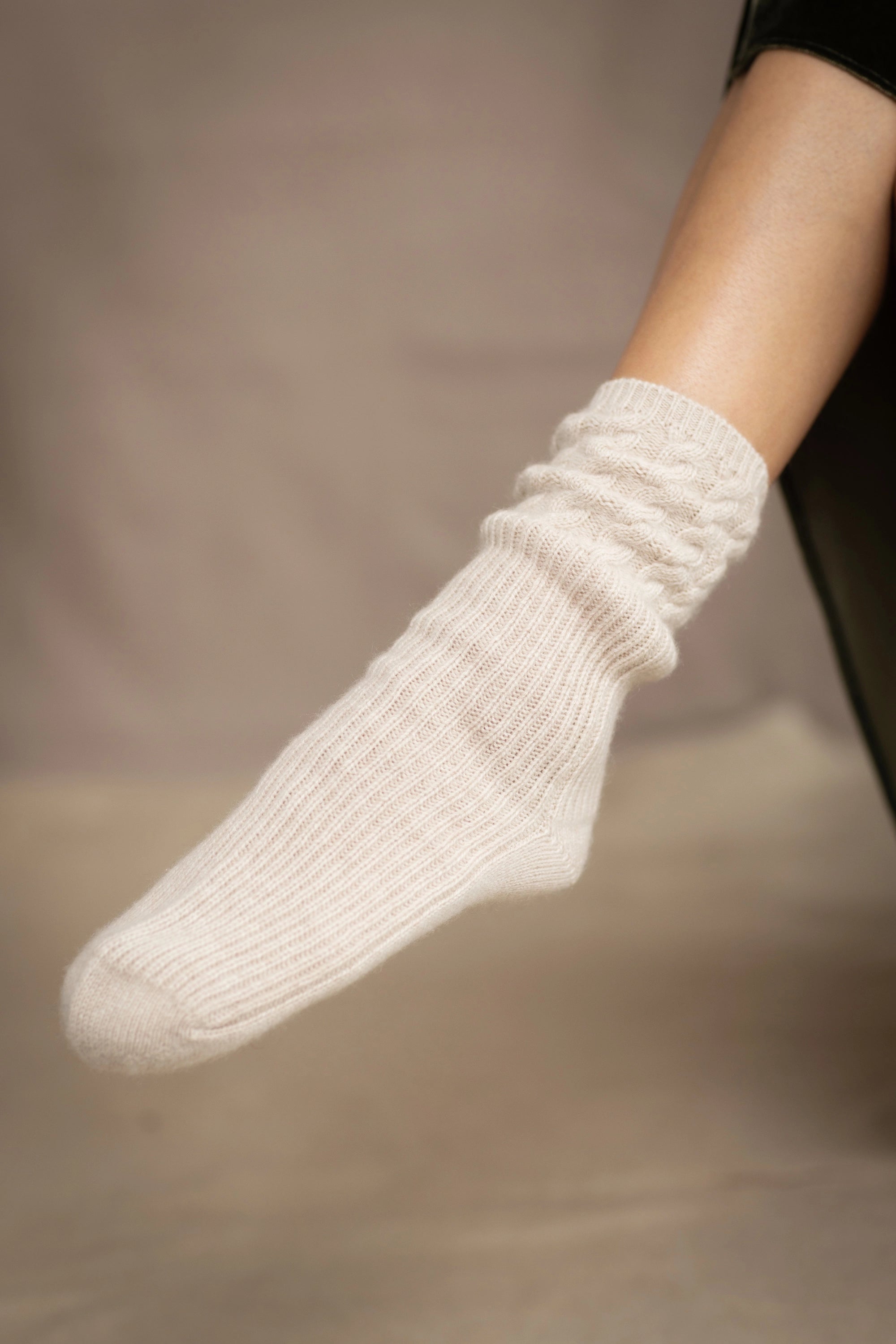beige cashmere socks with cable detail around the ankle