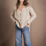 A lady wears a traditional Irish Cashmere Aran Cardigan Sweater in Beige