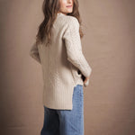 A lady wears a traditional Irish Cashmere Aran Cardigan Sweater in Beige