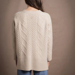A lady wears a traditional Irish Cashmere Aran Cardigan Sweater in Beige