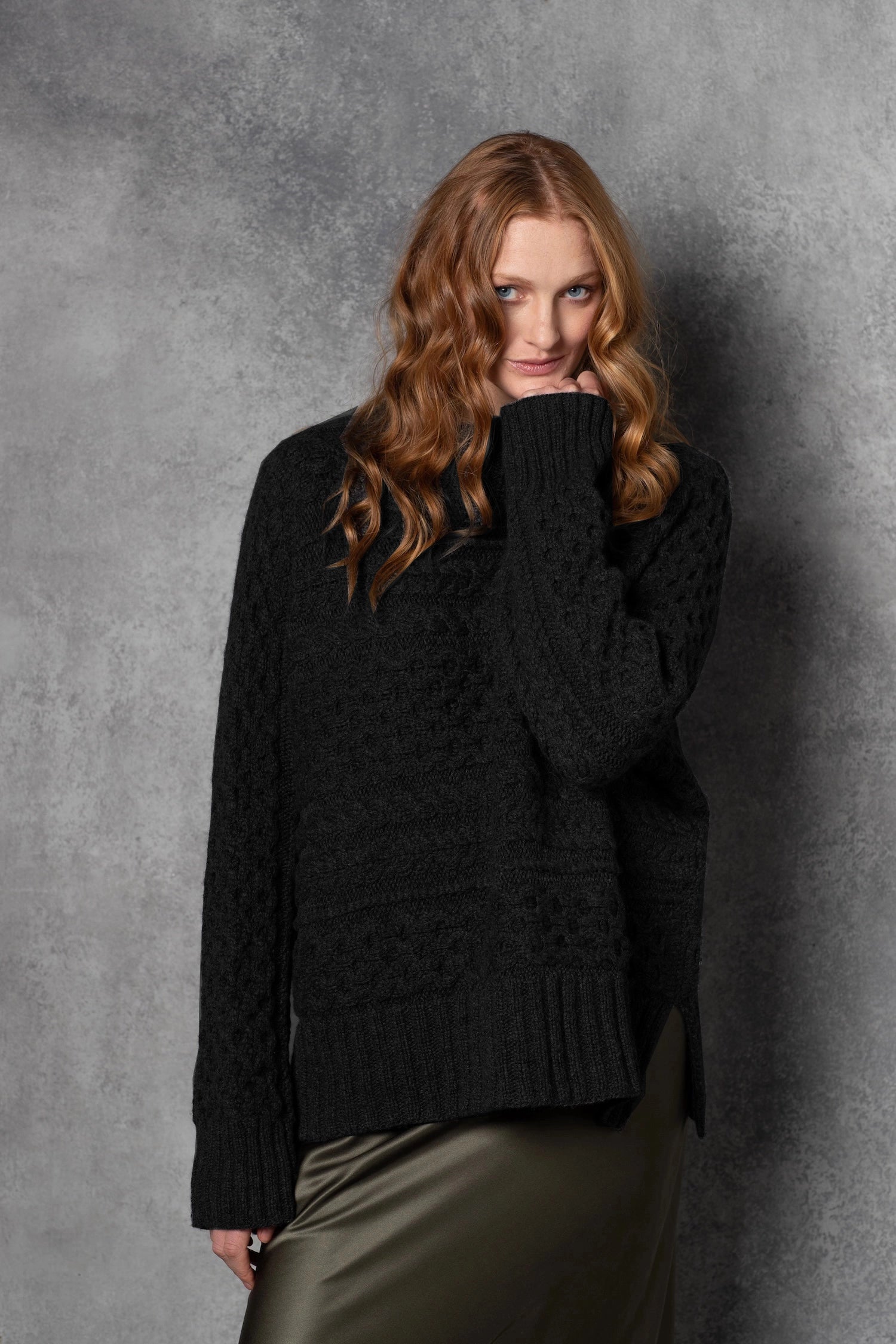 Redhead lady wears pure cashmere aran sweater from Ireland in black