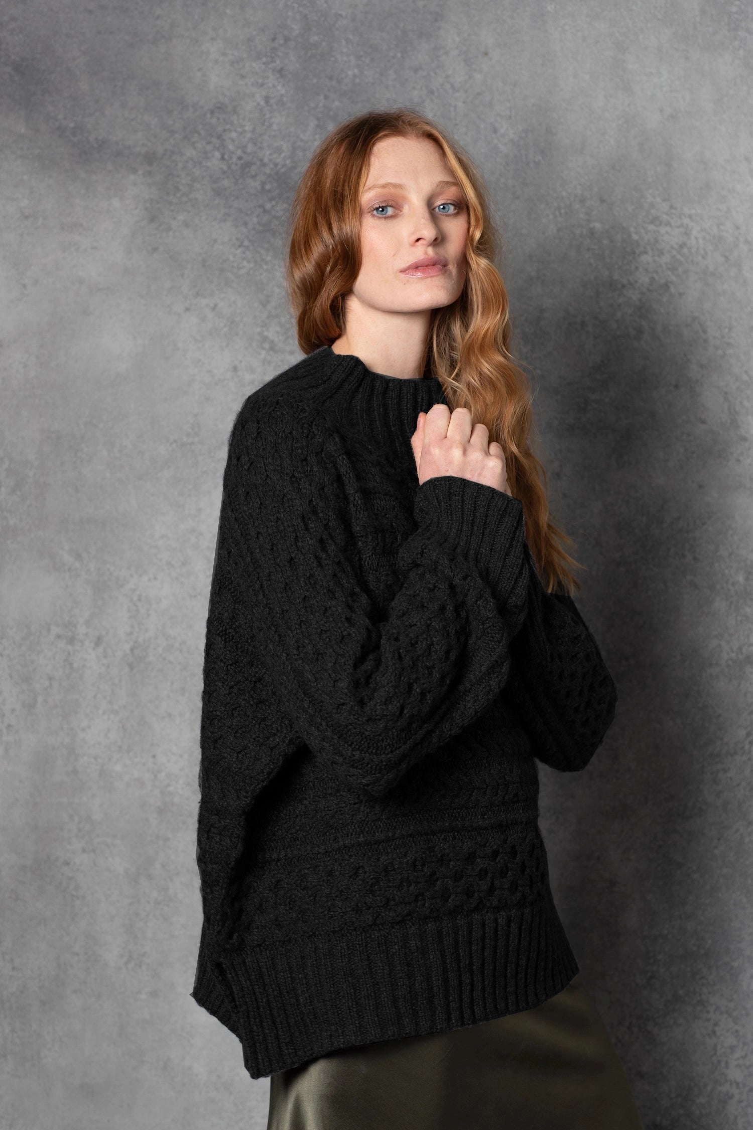 Redhead lady wears pure cashmere aran sweater from Ireland in black