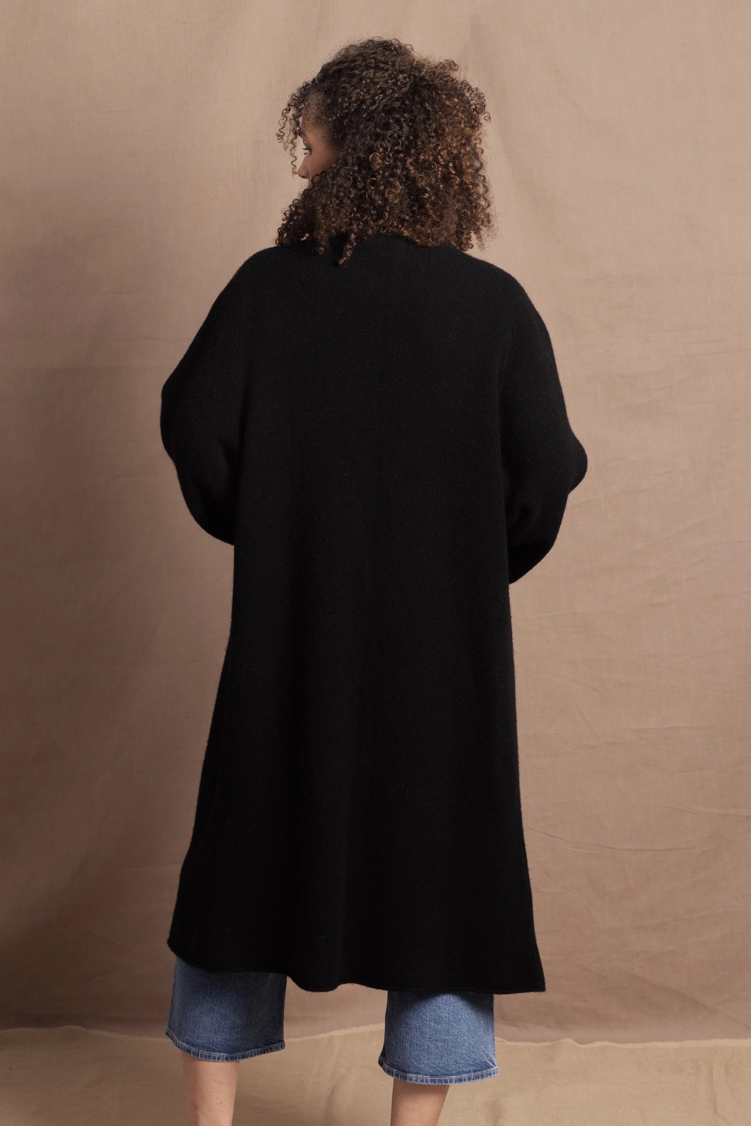 Lady wears luxury cashmere tee sweater in beige with long cashmere kaftan coat over top