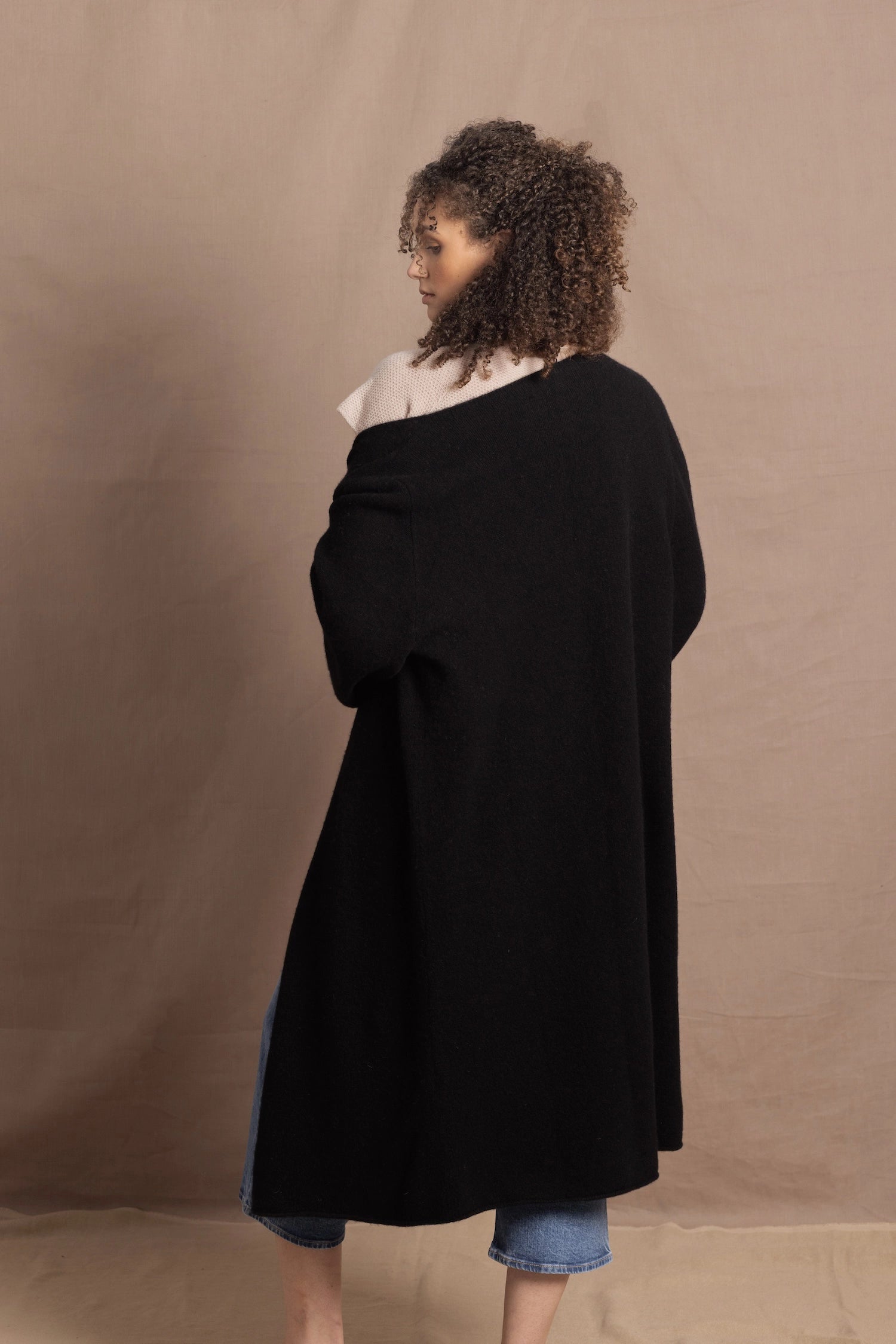 Lady wears luxury cashmere tee sweater in beige with long cashmere kaftan coat over top