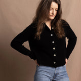 a woman wears a cashmere button down cardigan in black