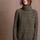 a lady wears a 100% cashmere aran sweater in fern green