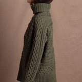 a lady wears a 100% cashmere aran sweater in fern green