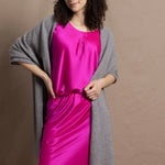 Lady wears large cashmere wrap shawl in Grey against bright pink silk clothing