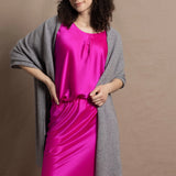 Lady wears large cashmere wrap shawl in Grey against bright pink silk clothing