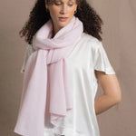 Lady wears luxurious cashmere wrap scarf in pale pink