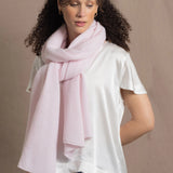 Lady wears luxurious cashmere wrap scarf in pale pink
