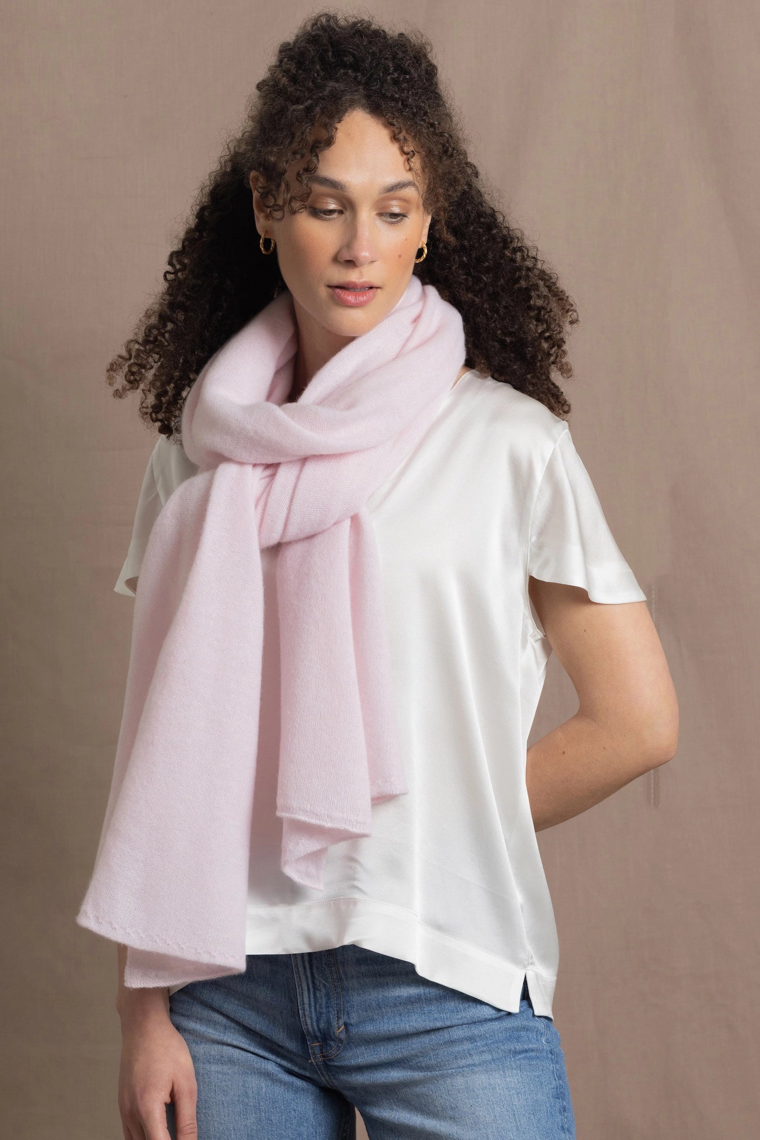 Lady wears luxurious cashmere wrap scarf in pale pink