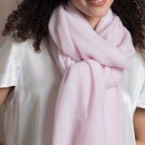Lady wears luxurious cashmere wrap scarf in pale pink