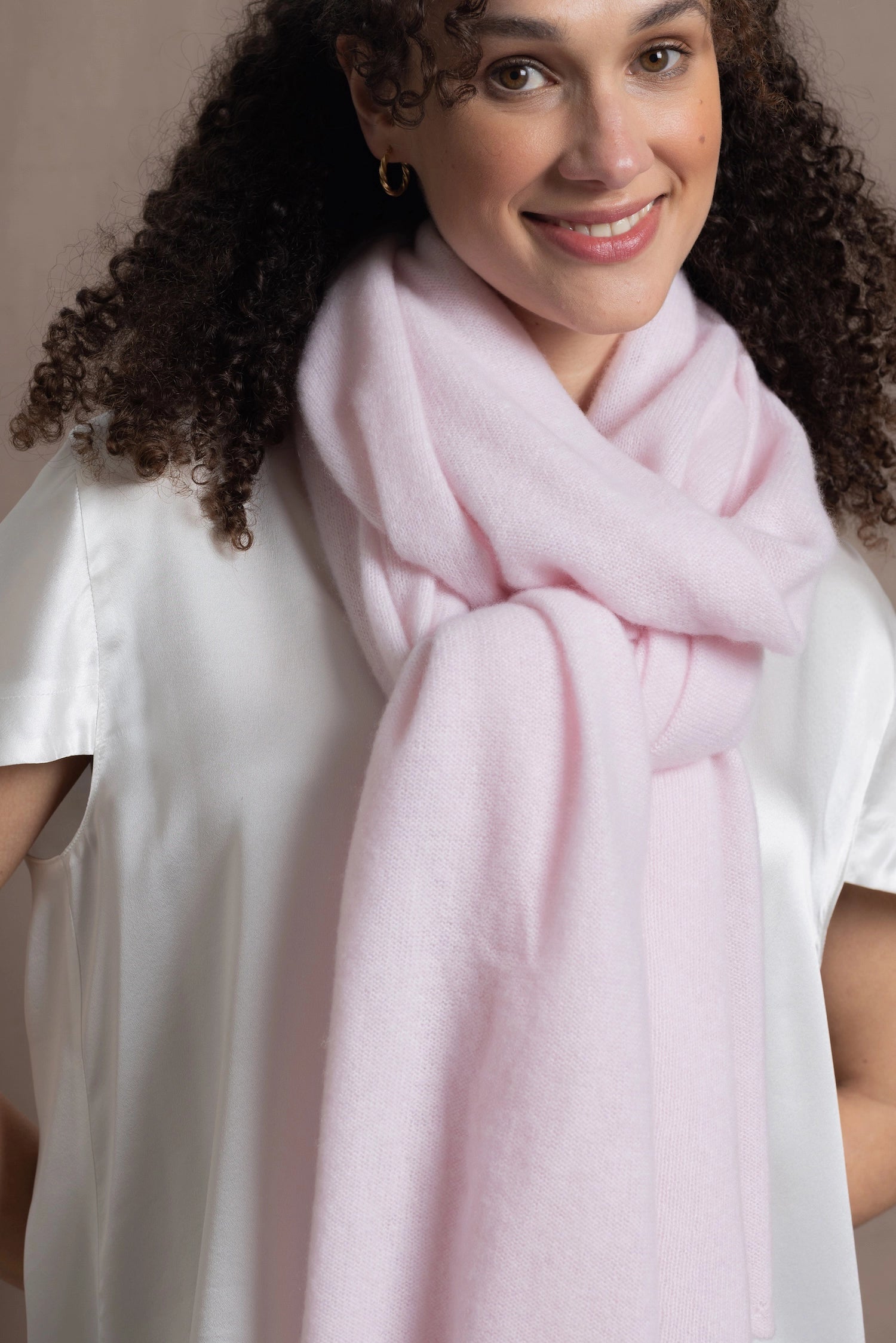 Lady wears luxurious cashmere wrap scarf in pale pink