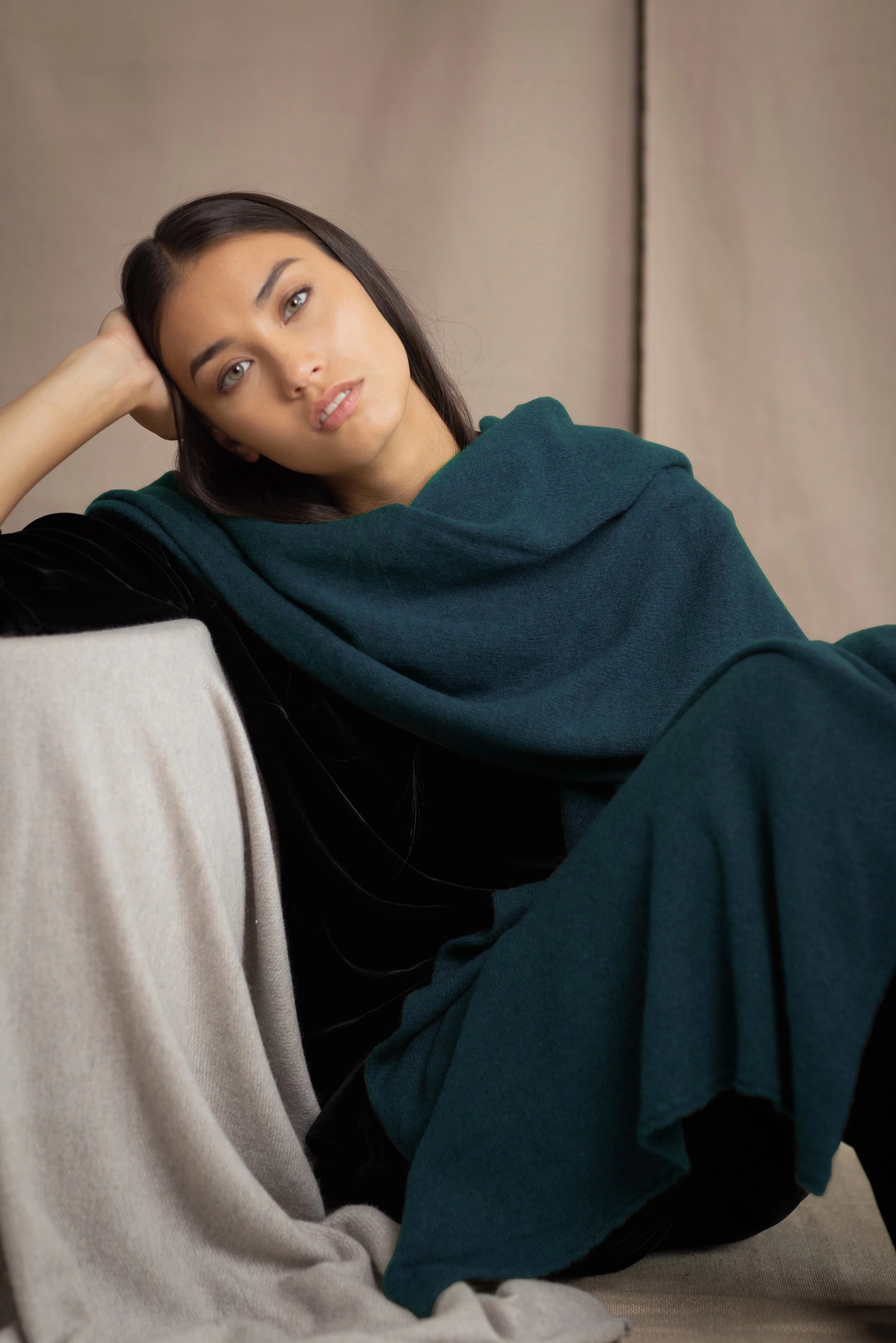 a woman wearing a large cashmere wrap shawl in teal blue
