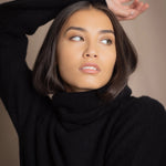 Woman wearing a black cashmere fisherman turtleneck sweater jumper