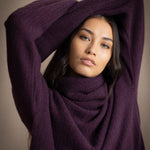 Woman wearing a cashmere fisherman turtleneck sweater in dark purple