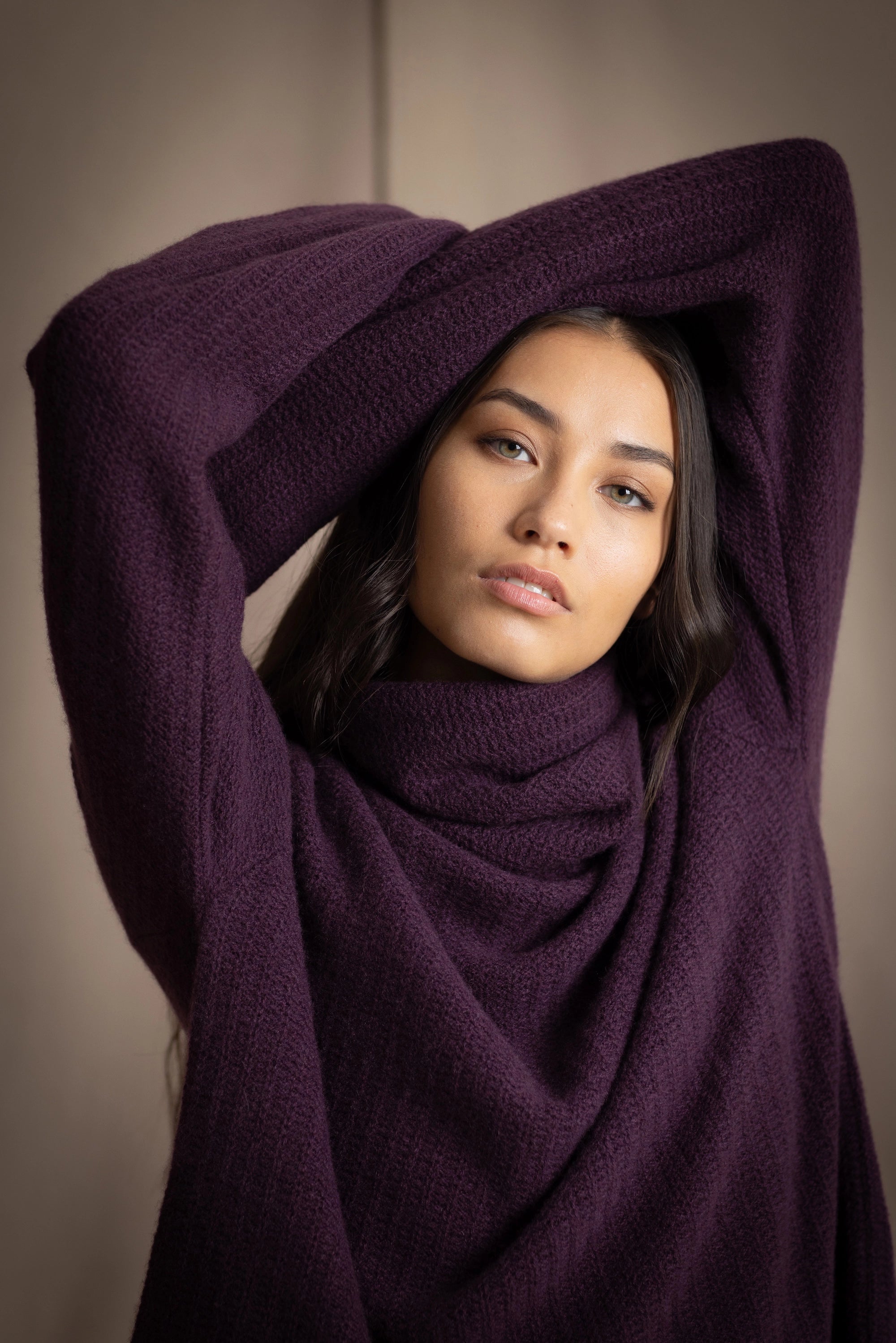 Woman wearing a cashmere fisherman turtleneck sweater in dark purple
