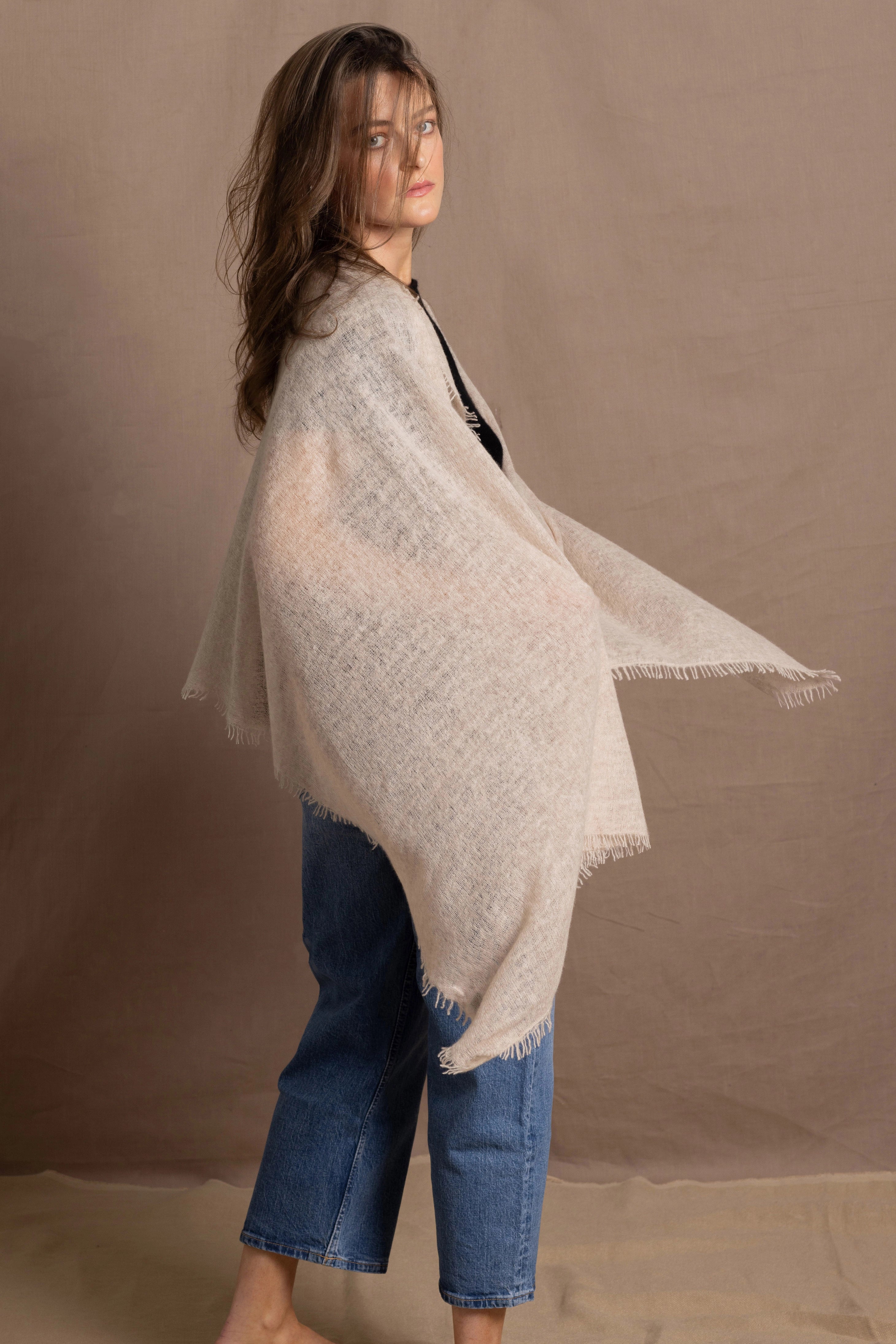 A woman wears a lightweight, fine cashmere shawl in beige