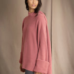 woman wearing an oversized cashmere sweater with hood in dusty pink rose colour