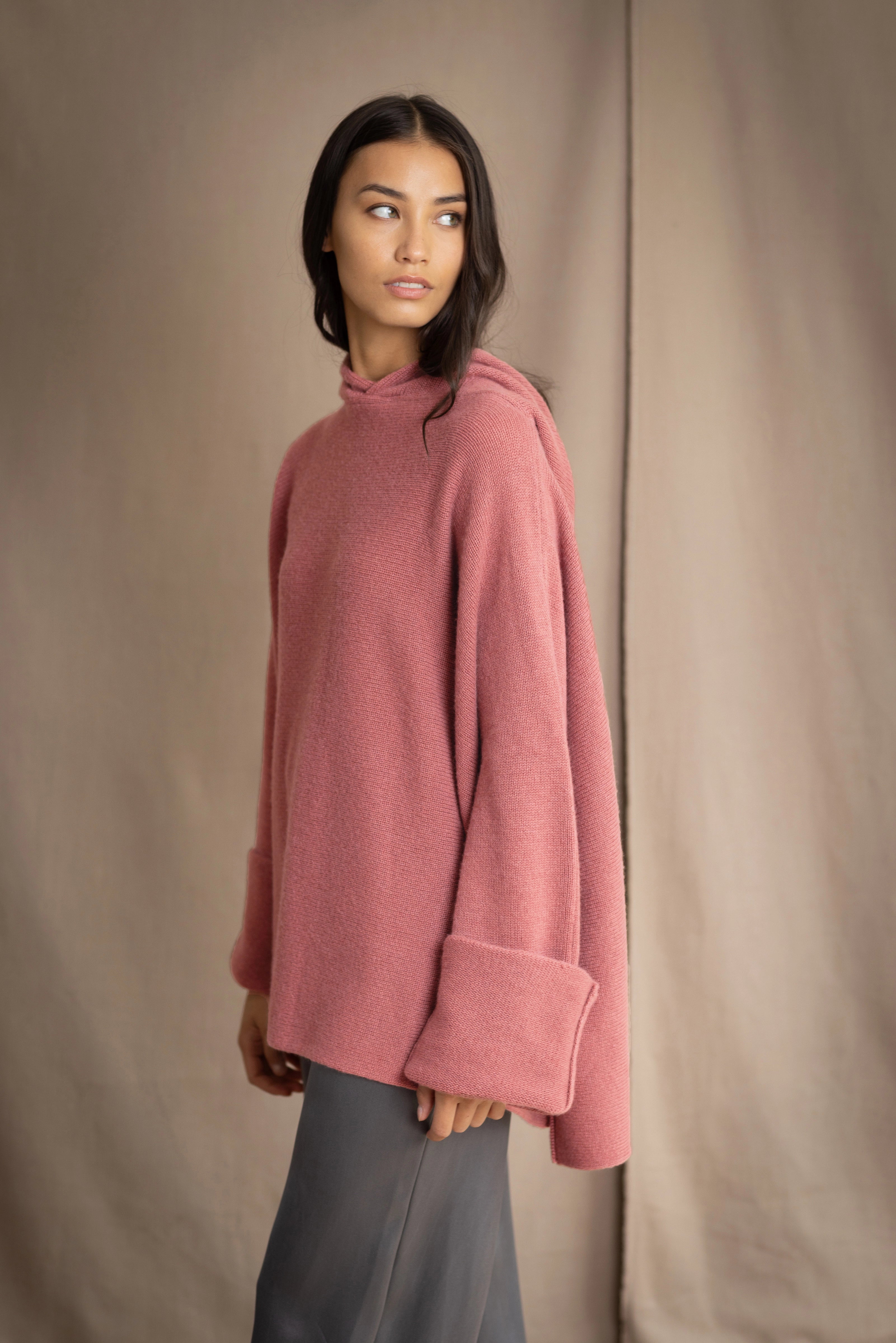 woman wearing an oversized cashmere sweater with hood in dusty pink rose colour
