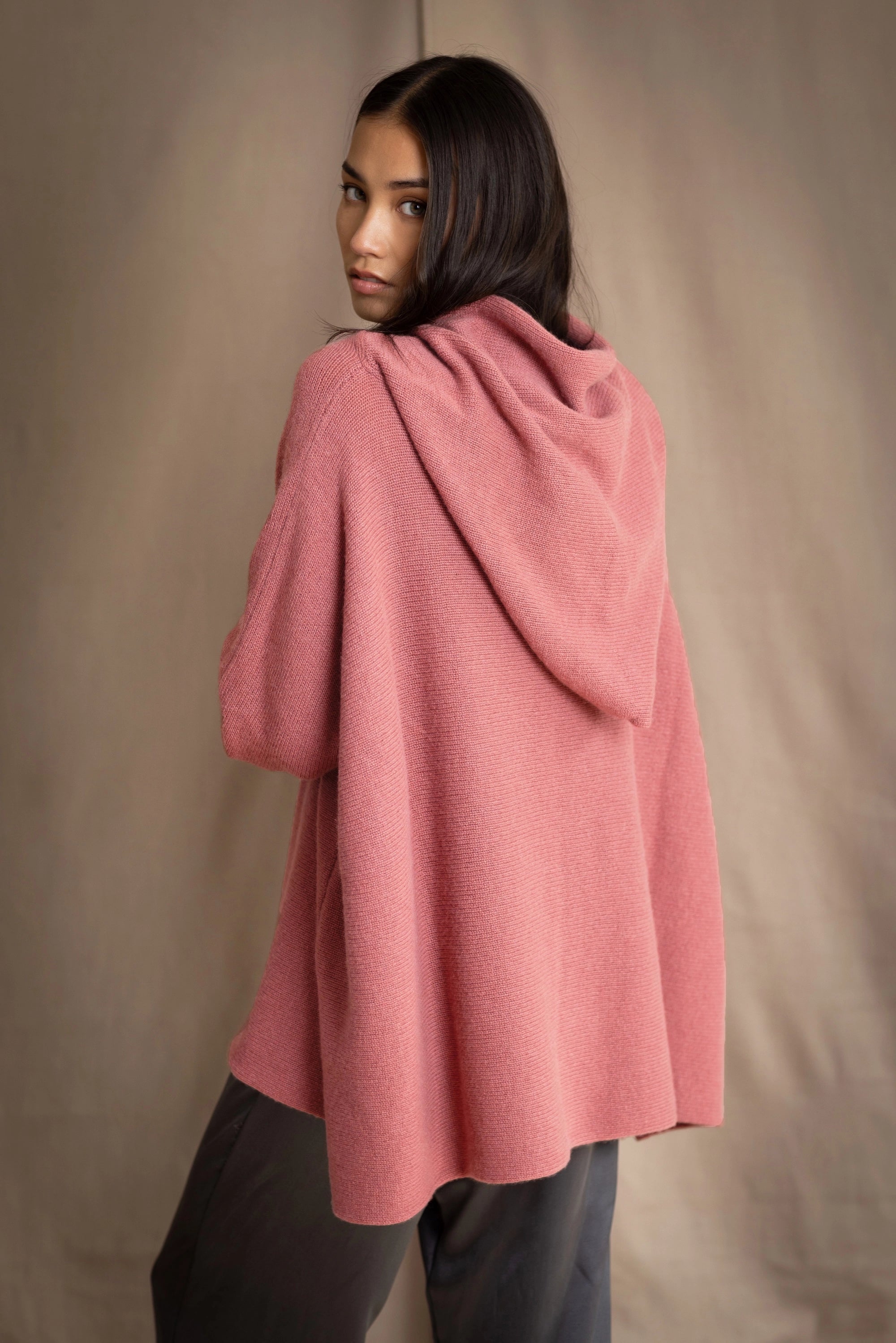 woman wearing an oversized cashmere sweater with hood in dusty pink rose colour