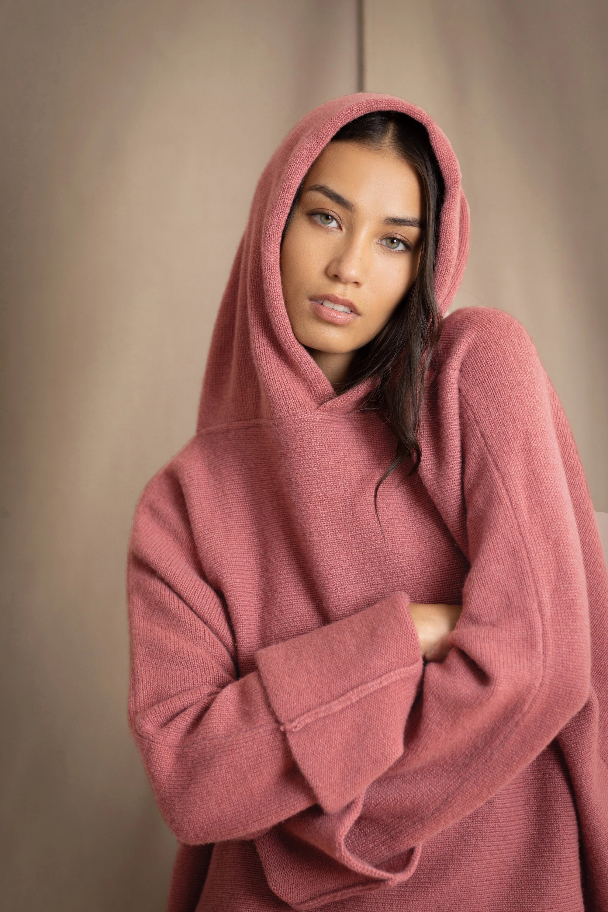 woman wearing an oversized cashmere sweater with hood in dusty pink rose colour