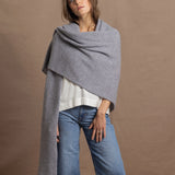 A woman wears a 100% cashmere wrap shawl in grey