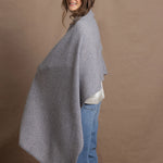 A woman wears a 100% cashmere wrap shawl in grey