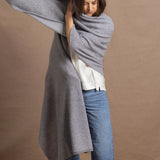 A woman wears a 100% cashmere wrap shawl in grey