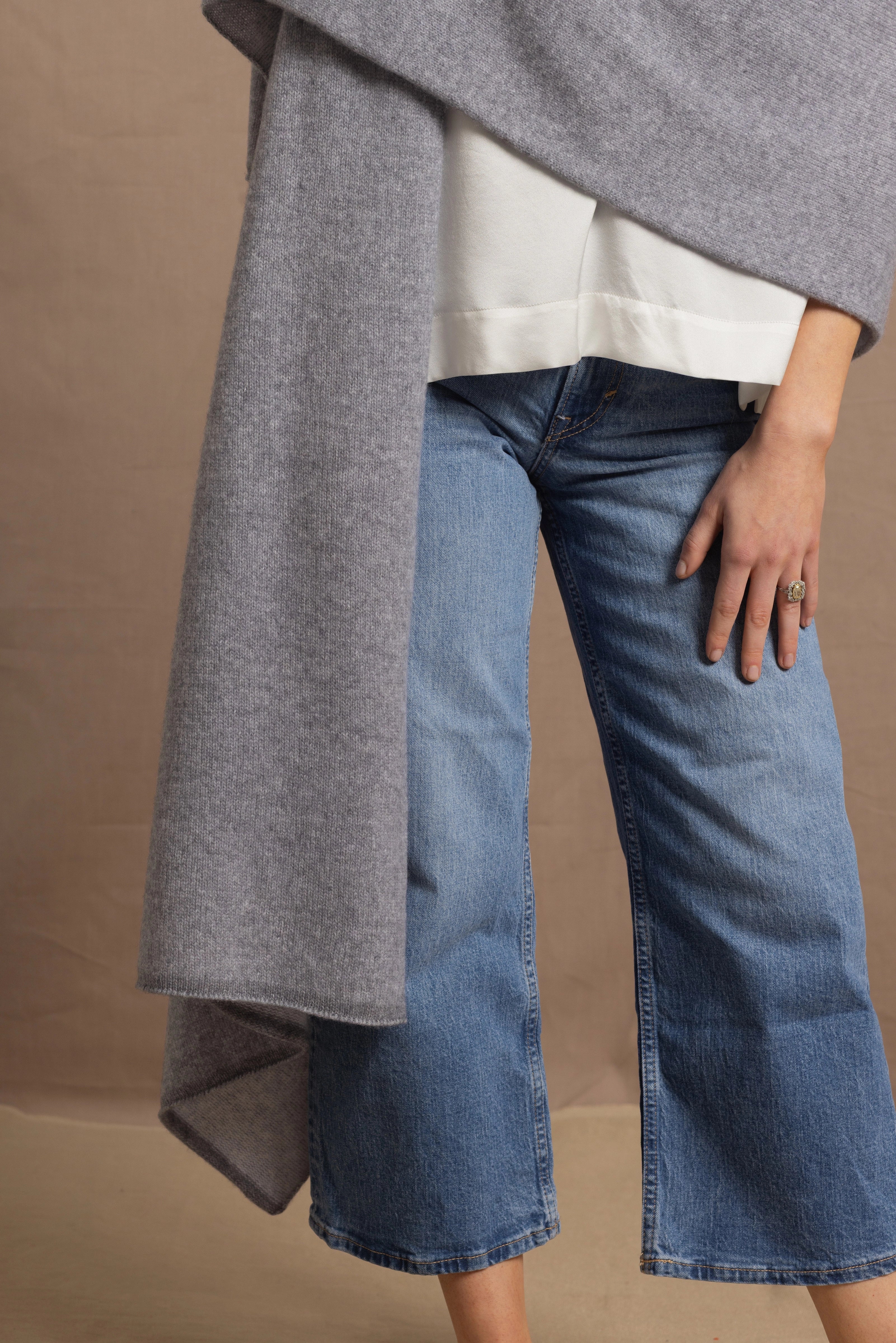 A woman wears a 100% cashmere wrap shawl in grey
