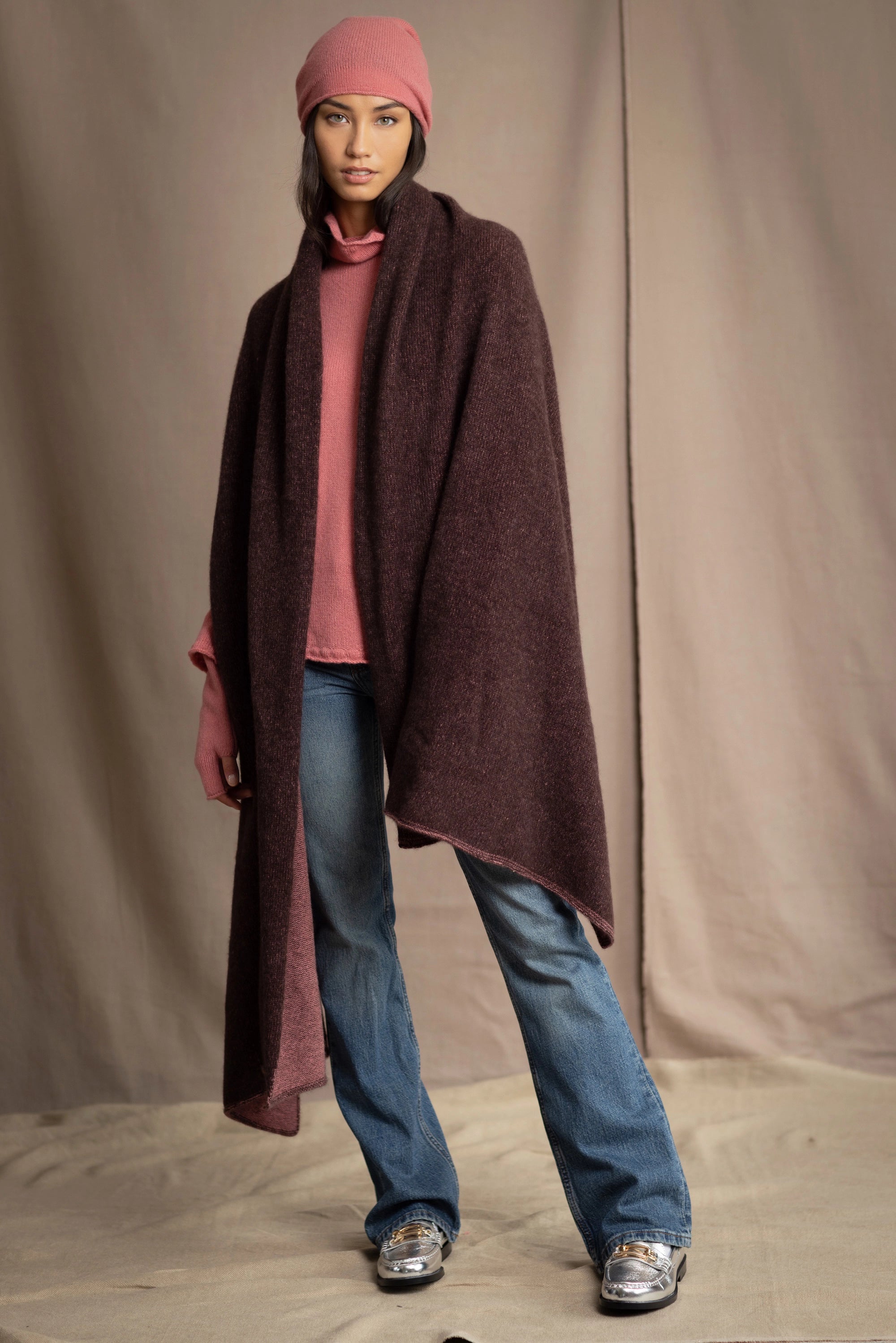 woman wears a long cashmere wrap shawl in dark brown and dusty rose pink with cashmere beanie hat in dusty rose pink