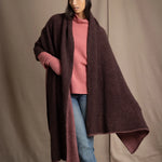 woman wears a long cashmere wrap shawl in dark brown and dusty rose pink with cashmere beanie hat in dusty rose pink