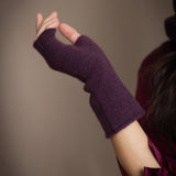 a woman wearing cashmere fingerless gloves in dark purple
