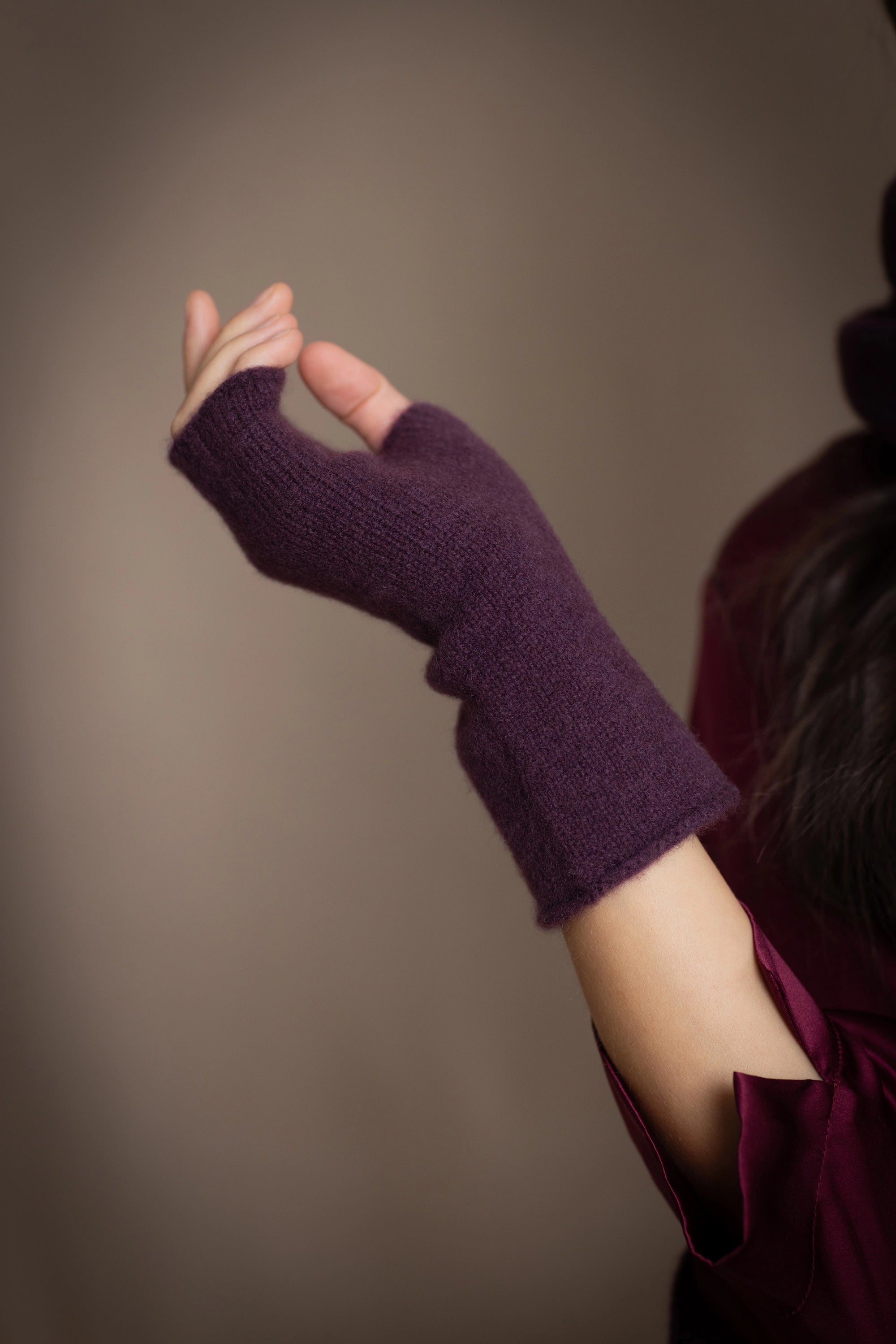 a woman wearing cashmere fingerless gloves in dark purple