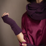 a woman wearing cashmere fingerless gloves in dark purple with burgundy silk top and matching cashmere snood in dark purple