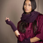 a woman wearing cashmere fingerless gloves in dark purple with burgundy silk top and matching cashmere snood in dark purple