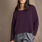 Woman wearing a purple cashmere sweater and gray silk pants
