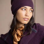 a woman wears a cashmere beanie hat in dark purple