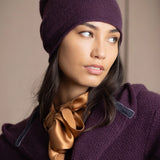 a woman wears a cashmere beanie hat in dark purple