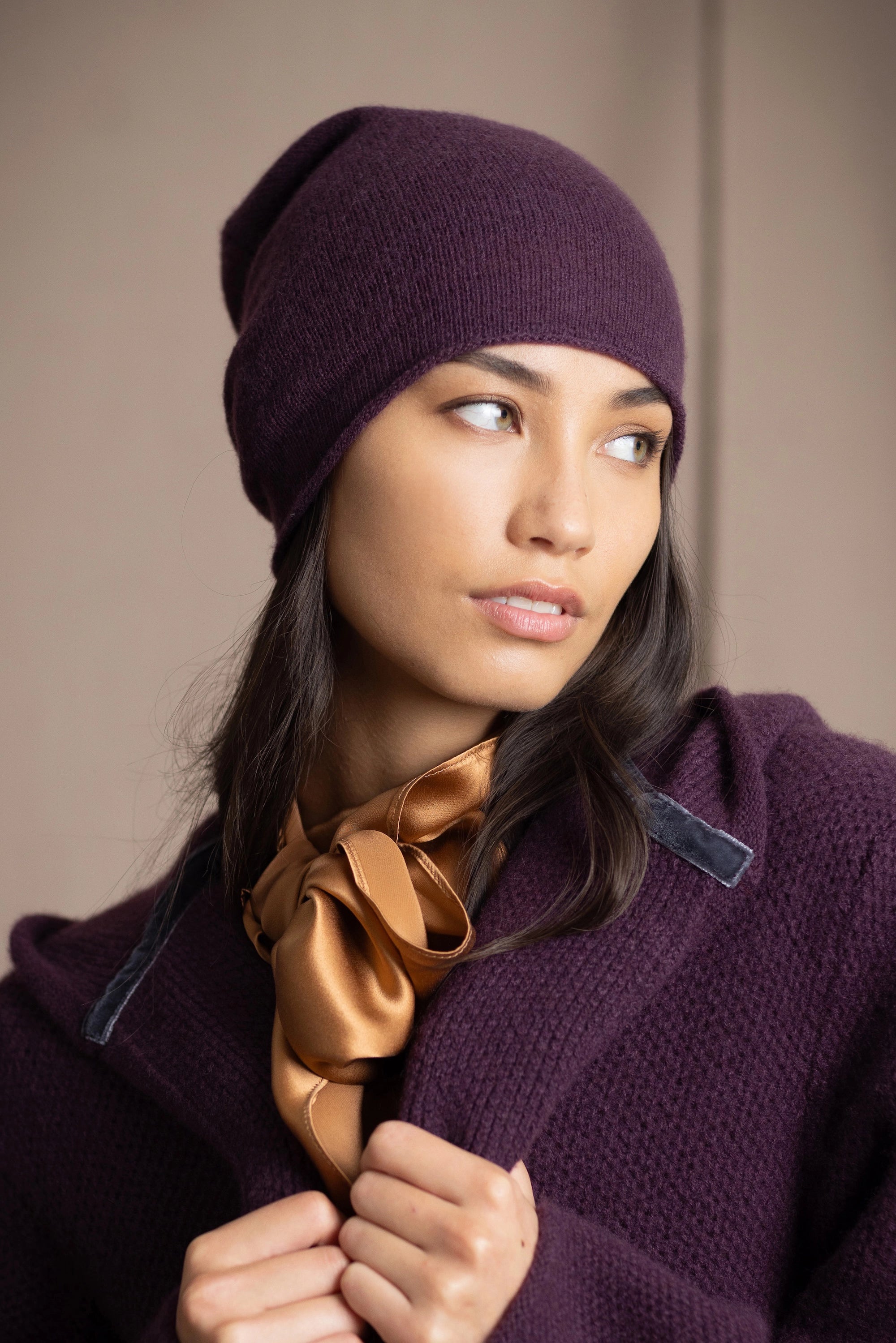 a woman wears a cashmere beanie hat in dark purple