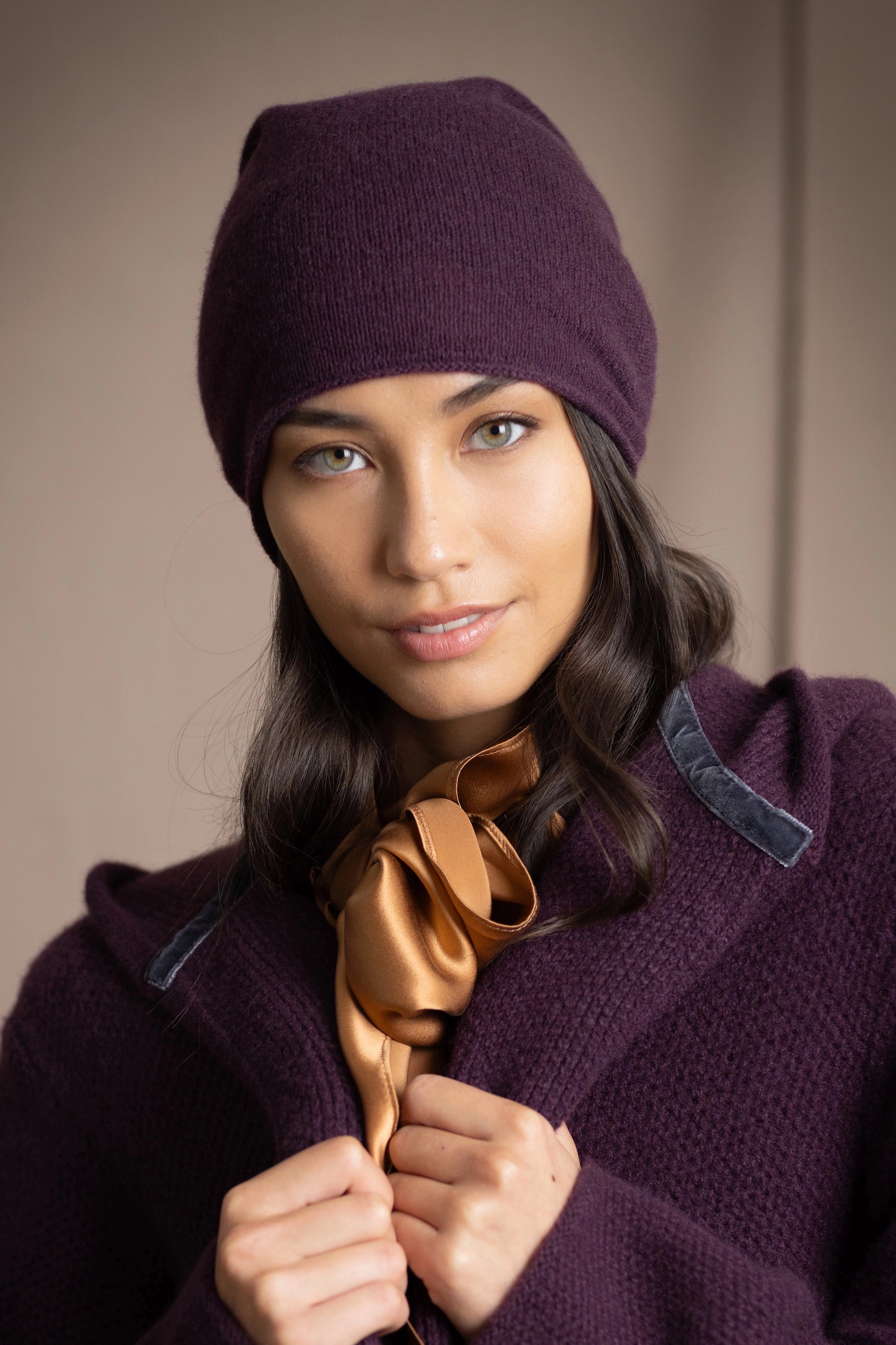 a woman wears a cashmere beanie hat in dark purple