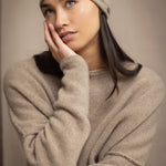 woman wears a cashmere beanie hat in beige with metallic gold lurex thread