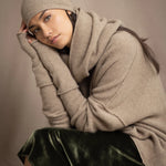 woman wears a cashmere beanie hat in beige with metallic gold lurex thread