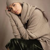 woman wears a cashmere beanie hat in beige with metallic gold lurex thread