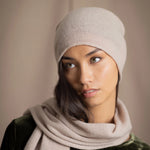 a woman wears a cashmere beanie hat in beige