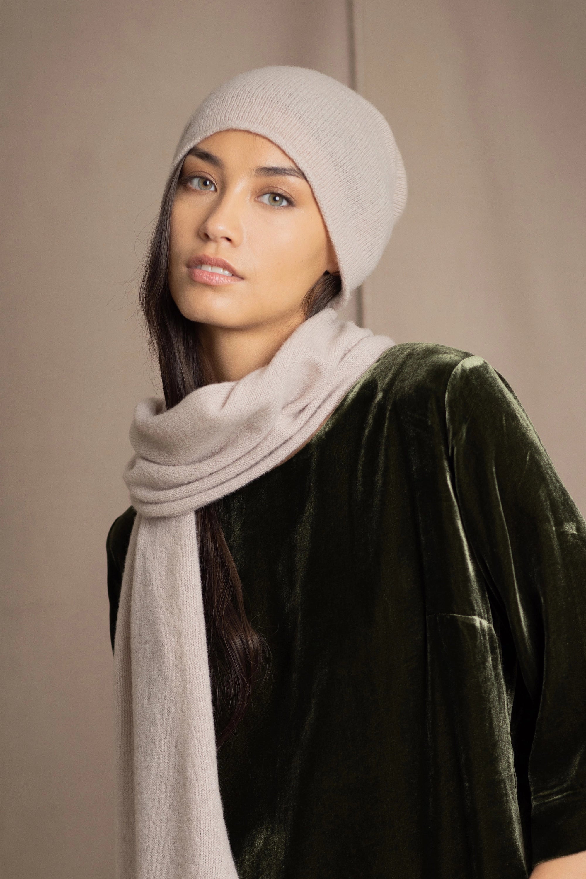 a woman wears a cashmere beanie hat in beige with matching cashmere scarf