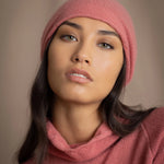 a woman wears a cashmere beanie hat in dusty rose pink